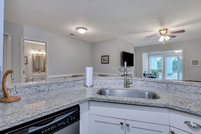 kitchen with sink, ceiling fan, white cabinetry, light stone counters, and stainless steel dishwasher