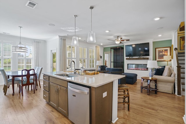 101 Caleb Ct, Ladson, SC 29456 - kitchen with stainless steel dishwasher, a sink, an island with sink, decorative light fixtures, and ornamental molding