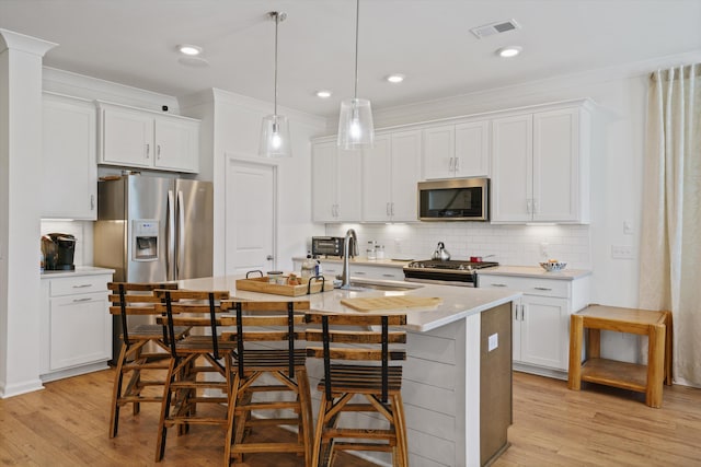 101 Caleb Ct, Ladson, SC 29456 - kitchen featuring stainless steel appliances, light wood finished floors, white cabinets, and an island with sink