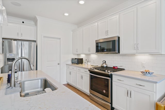 101 Caleb Ct, Ladson, SC 29456 - kitchen with appliances with stainless steel finishes, a sink, white cabinets, recessed lighting, and crown molding