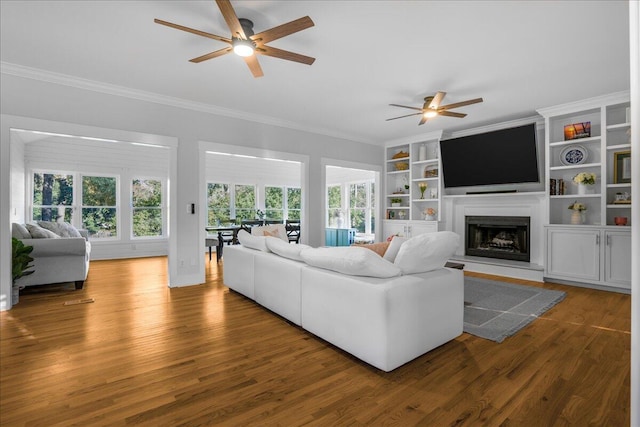 living room with hardwood / wood-style flooring, ceiling fan, and ornamental molding