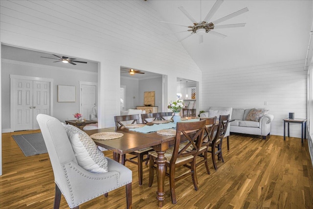 dining space featuring crown molding, high vaulted ceiling, and dark hardwood / wood-style floors