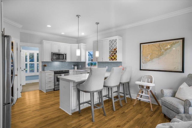 kitchen featuring stainless steel appliances, white cabinetry, and hardwood / wood-style flooring