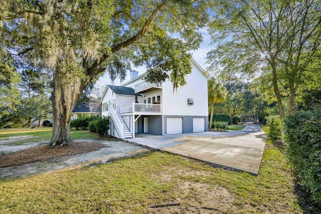 view of side of property featuring a lawn, a wooden deck, and a garage