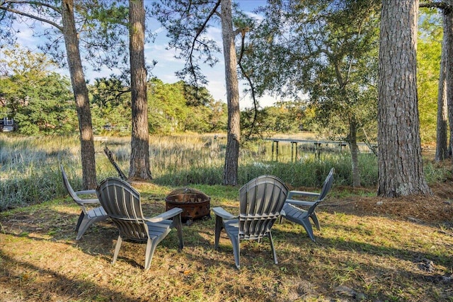 view of yard with a water view and a fire pit