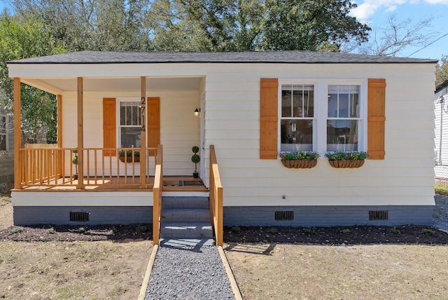 view of front of home with crawl space, roof with shingles, and covered porch