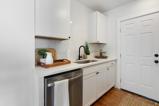 kitchen featuring a sink, wood finished floors, white cabinetry, light countertops, and dishwasher