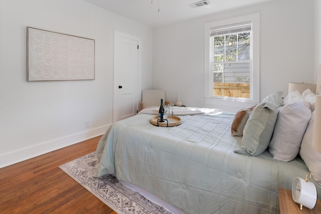 bedroom featuring visible vents, wood finished floors, and baseboards