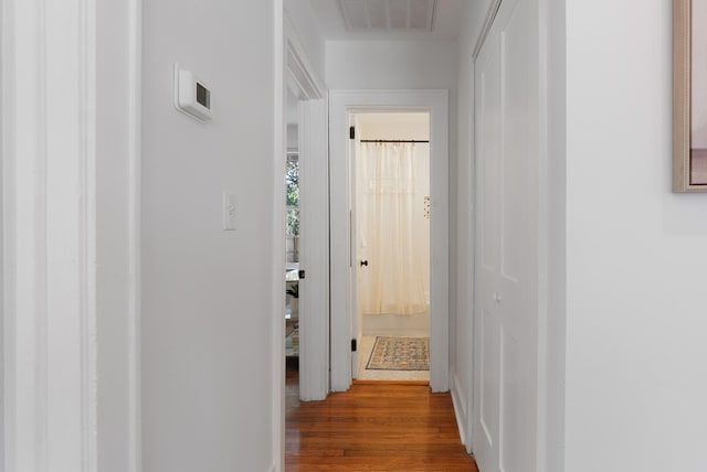 hall with wood finished floors and visible vents