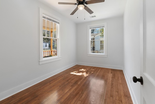 spare room with visible vents, a ceiling fan, baseboards, and wood-type flooring