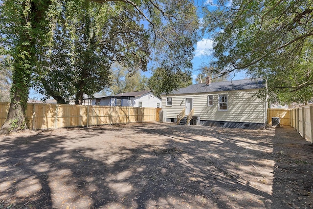 back of property featuring crawl space, entry steps, central AC, and a fenced backyard