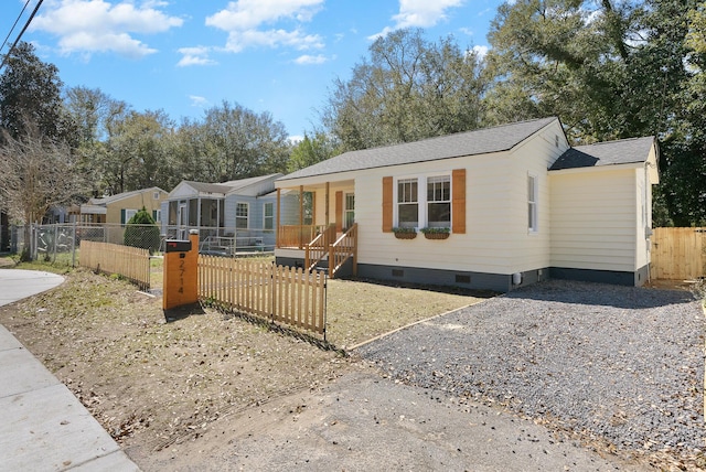 manufactured / mobile home featuring crawl space, a shingled roof, gravel driveway, and a fenced front yard