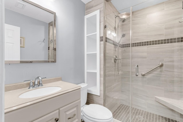 bathroom with visible vents, toilet, a stall shower, and vanity