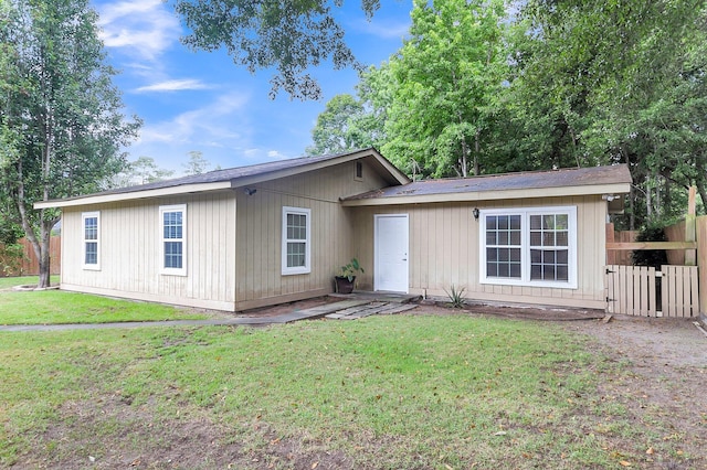 ranch-style house featuring a front lawn and fence