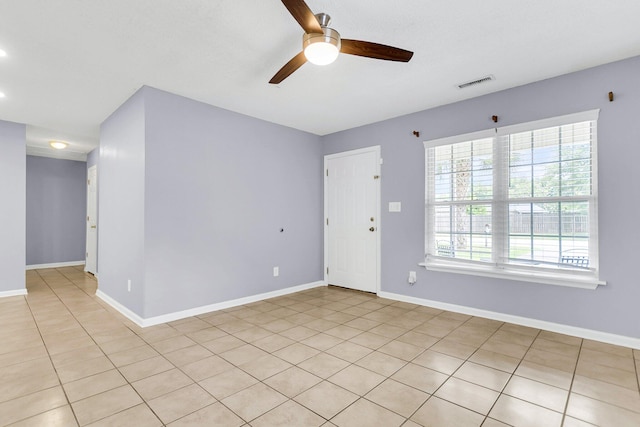 unfurnished room with light tile patterned floors, visible vents, baseboards, and ceiling fan