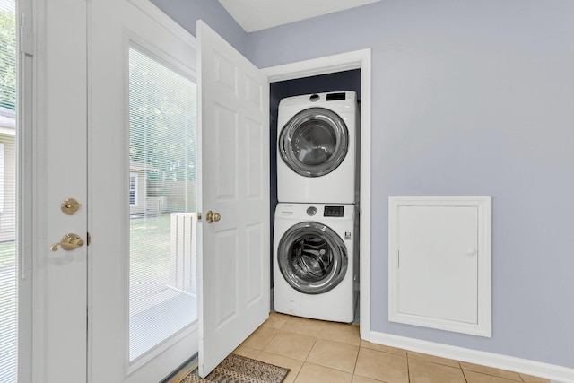 laundry room featuring light tile patterned floors and stacked washer and dryer