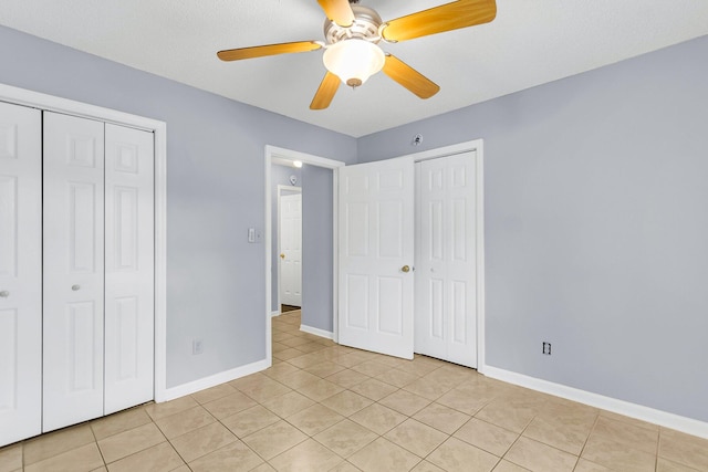 unfurnished bedroom featuring light tile patterned floors, a ceiling fan, and baseboards