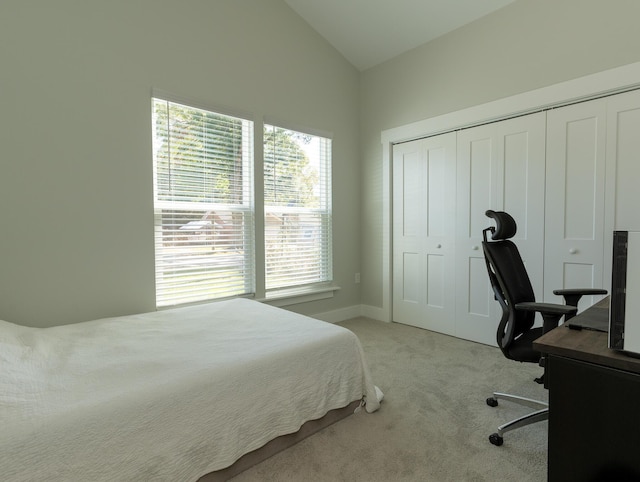 bedroom featuring lofted ceiling, light colored carpet, and a closet