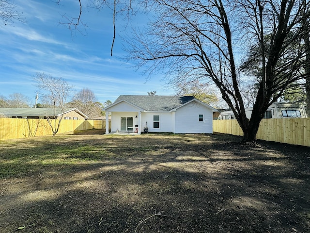 rear view of property with a yard