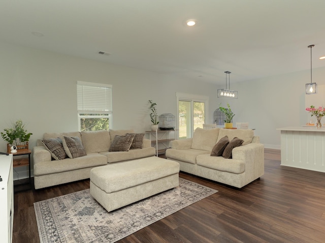 living room with a wealth of natural light and dark wood-type flooring