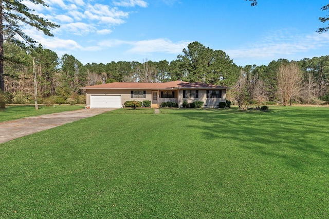 ranch-style home featuring a garage, a forest view, concrete driveway, and a front yard