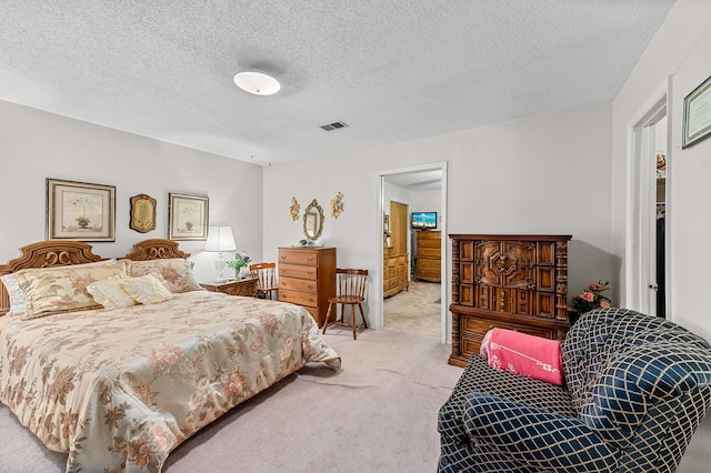 carpeted bedroom featuring a textured ceiling and visible vents