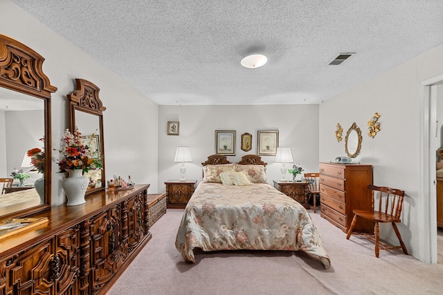 carpeted bedroom featuring visible vents and a textured ceiling