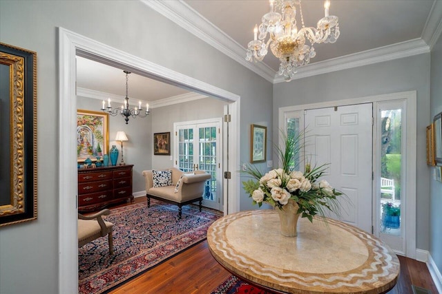 foyer with plenty of natural light, crown molding, and hardwood / wood-style floors