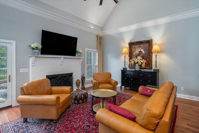 living room with hardwood / wood-style floors, ornamental molding, and a brick fireplace