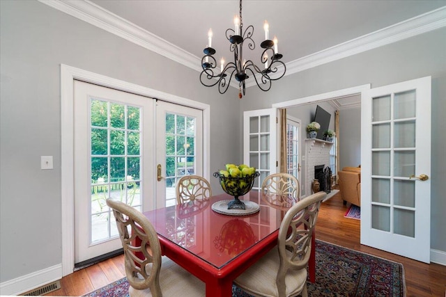 dining room with a wealth of natural light, a notable chandelier, hardwood / wood-style floors, and french doors