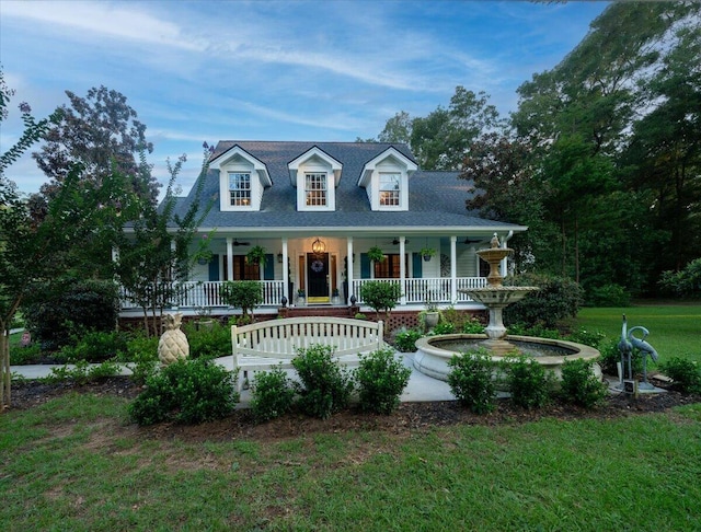 cape cod-style house featuring a front lawn and covered porch