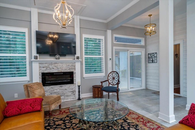 living room with an inviting chandelier, ornamental molding, tile patterned flooring, and a fireplace