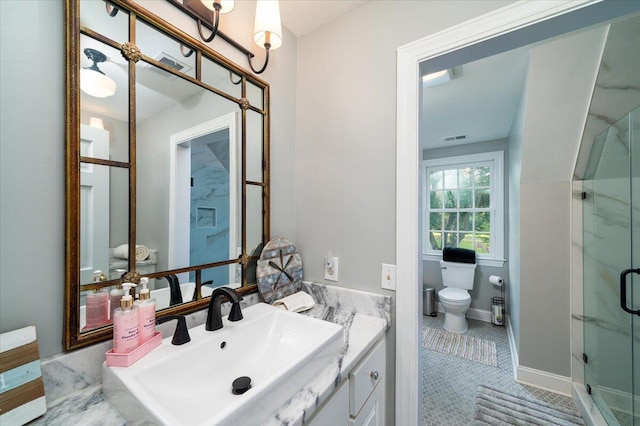 bathroom featuring tile patterned flooring, toilet, vanity, and a shower with shower door