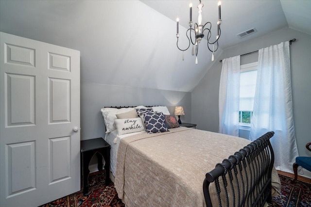 bedroom featuring lofted ceiling and an inviting chandelier