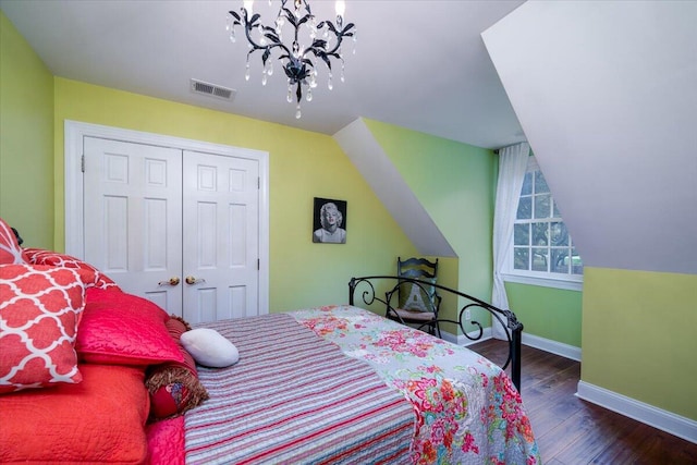 bedroom featuring a closet, a notable chandelier, hardwood / wood-style floors, and vaulted ceiling