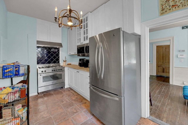 197 Coming St, Charleston, SC 29403 - kitchen with stainless steel appliances, under cabinet range hood, a notable chandelier, and white cabinetry