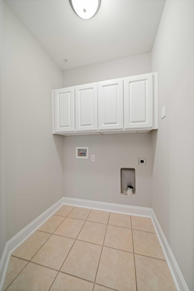 washroom with electric dryer hookup, light tile patterned flooring, cabinets, and hookup for a washing machine