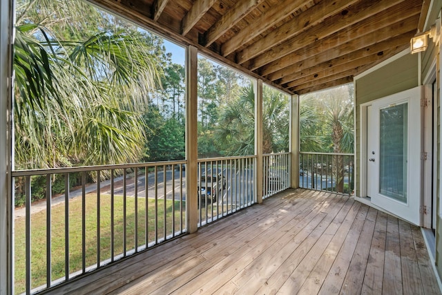 unfurnished sunroom featuring beam ceiling