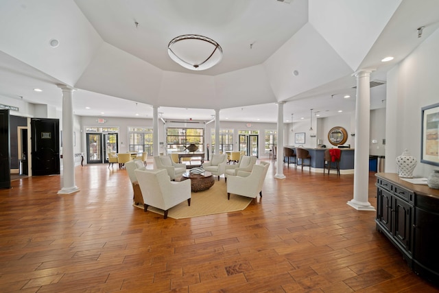 living room featuring wood-type flooring, high vaulted ceiling, and french doors