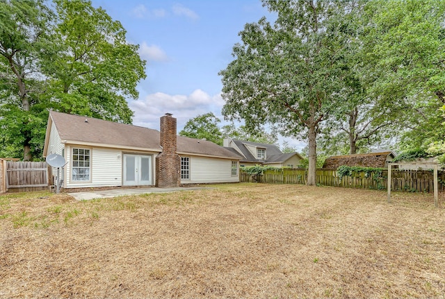 315 Indigo Rd, Goose Creek, SC 29445 - back of house with a chimney, a fenced backyard, a patio area, french doors, and roof with shingles