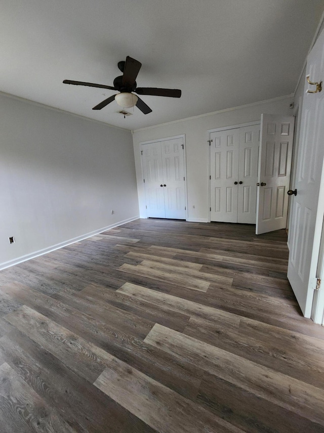 315 Indigo Rd, Goose Creek, SC 29445 - unfurnished bedroom featuring dark wood-type flooring, baseboards, two closets, and crown molding