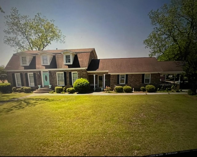 cape cod house featuring a front lawn
