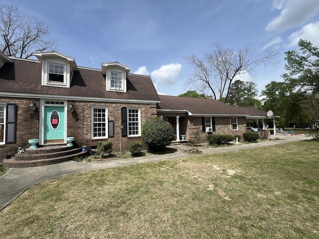 view of front facade featuring a front yard and brick siding