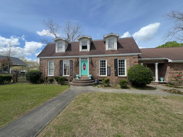 cape cod-style house with a front yard and brick siding
