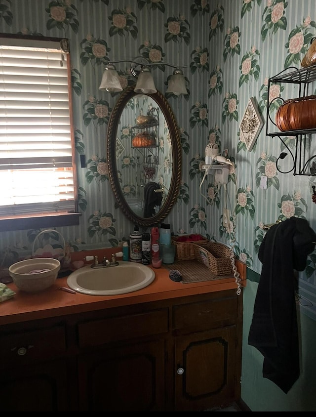bathroom with wallpapered walls and vanity