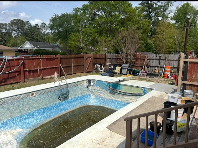 view of pool with a fenced in pool, a patio, a diving board, grilling area, and a fenced backyard