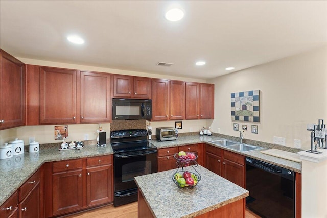 kitchen with a center island, a sink, visible vents, black appliances, and recessed lighting