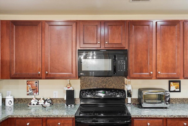 kitchen with a toaster, visible vents, light stone countertops, and black appliances