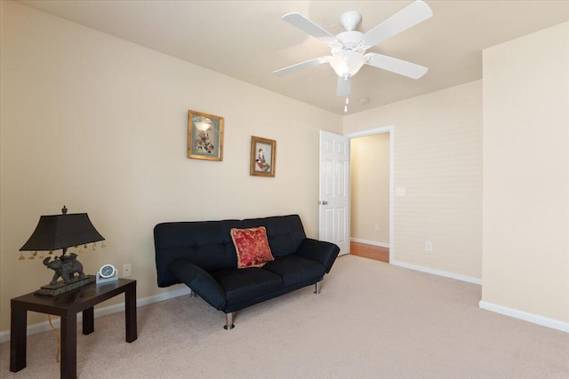 living area featuring baseboards, ceiling fan, and carpet floors
