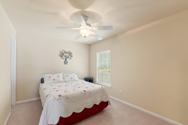 bedroom with baseboards, a ceiling fan, and light colored carpet